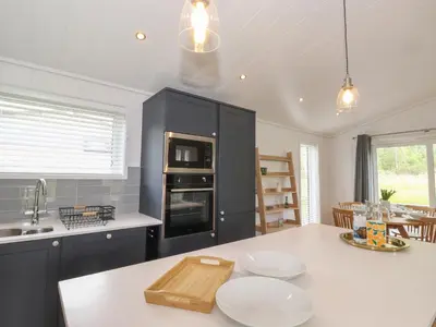 a kitchen with black cabinets and a white counter top at Blackthorn Copse in Ulverston