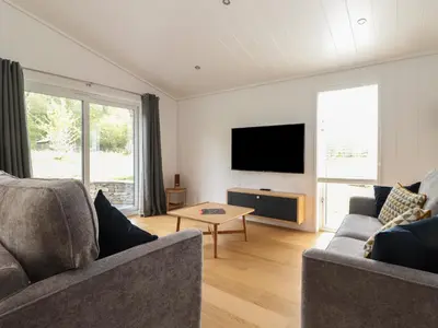 a living room with two couches and a flat screen tv at The Brambles in Ulverston