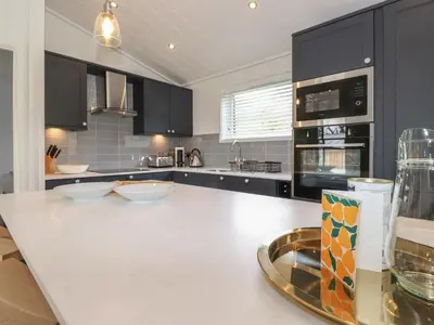 a kitchen with a white counter top and black cabinets at Ash Thwaite in Ulverston