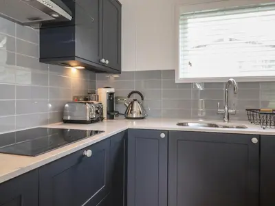 a kitchen with black cabinets and a sink at Ash Thwaite in Ulverston