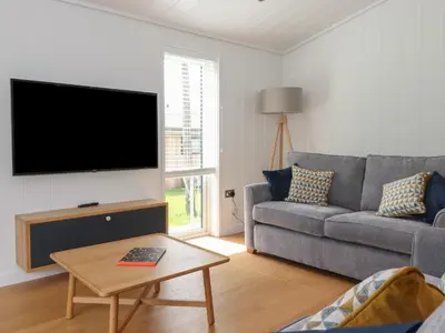 a living room with a couch and a flat screen tv at Ash Thwaite in Ulverston