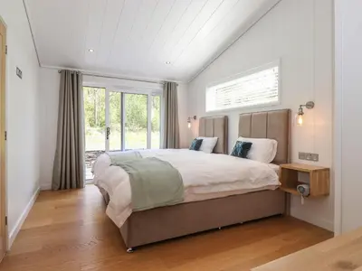 a bedroom with a large bed and a window at Hawthorn Croft in Ulverston