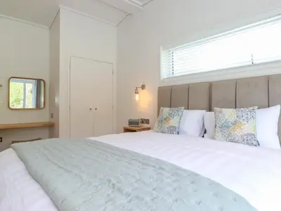 a bedroom with a large white bed with a window at Hawthorn Croft in Ulverston