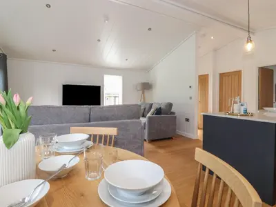 a living room with a table with white dishes on it at The Burrow in Ulverston