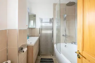 a bathroom with a tub and a toilet and a sink at Double Room l Large TV l Great Transport Links in Bolton