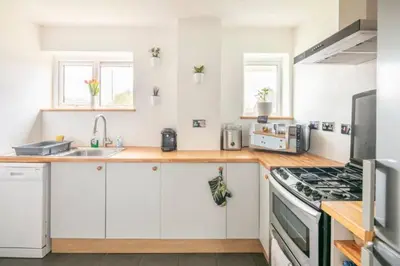 a kitchen with white cabinets and a stove top oven at Double Room l Large TV l Great Transport Links in Bolton