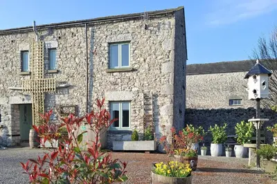 a stone building with plants in front of it at Corner Cottage at Brackenthwaite Farm in Carnforth