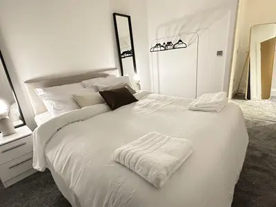 a bedroom with a white bed with white sheets and pillows at Elegant and Sophisticated, and we mean it! in Liverpool