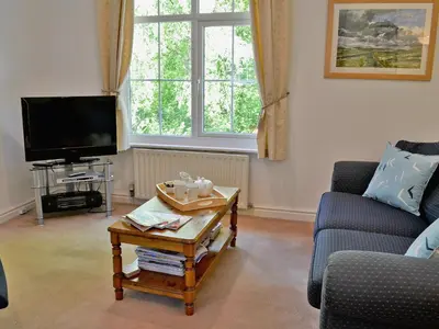 a living room with a coffee table and a tv at Hope Cottage in Lindale