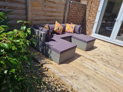 a patio with a couch and two pillows at Crabtree House in Moreton