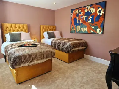 a bedroom with two beds and a painting on the wall at The Duke in Preston