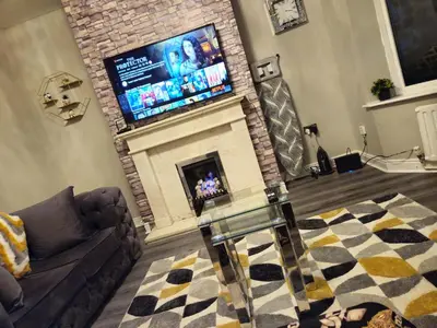 a living room with a fireplace with a flat screen tv at Clifton House, For Holidays, Contractors, Relocation, Work, Etc, Free Parking and Wifi in Preston