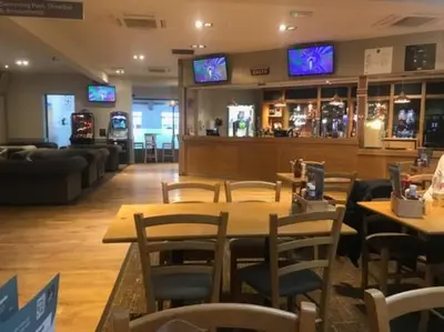 a restaurant with tables and chairs and televisions at Lorraine's Caravan Holiday in Morecambe