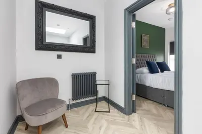 a bedroom with a mirror and a chair and a bed at Ettie and Gigi's in Blackpool