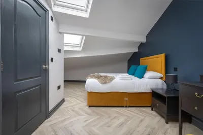 a bedroom with a bed with blue walls at Ettie and Gigi's in Blackpool