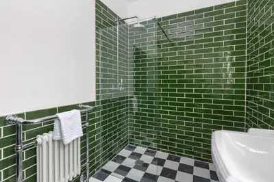 a green tiled bathroom with a sink and a toilet at GiGi's in Blackpool