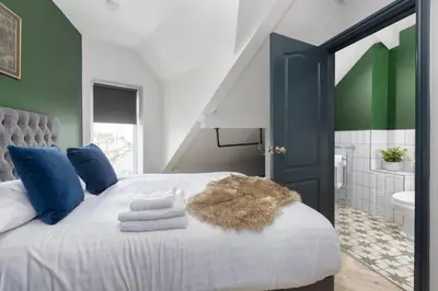 a bedroom with a large bed with blue and green walls at GiGi's in Blackpool