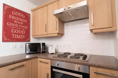 a kitchen with a stove and a sign on the wall at Central Liverpool Haven 3 bedroom House Private Parking in Liverpool