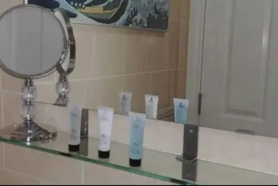 a mirror sitting on top of a counter in a bathroom at Large Studio Room in City Centre (Shared Bathroom) in Preston