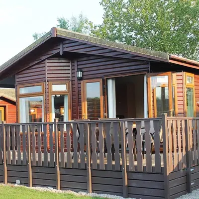 a log cabin with a wooden fence at Luxury 3 bedroom lodge with free in lodge wifi in Carnforth