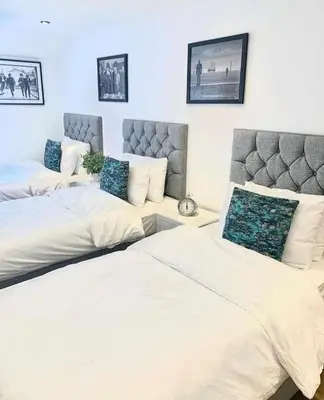 a bedroom with two beds and a couch at Camden Apartments 1 in Liverpool