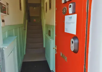 a hallway with a red door and a staircase at Pitchside Rooms Near Anfield in Liverpool