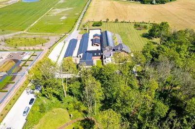 an aerial view of a large house in a field at Woodland Retreat in Lytham. in Lytham St Annes
