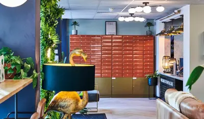 a dinosaur statue in a room with plants at For Students Only - Capital Gate in Liverpool in Liverpool
