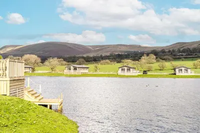 a view of a lake with houses and a dock at Wiswell View Lodge: Pendle View Holiday Park in Clitheroe