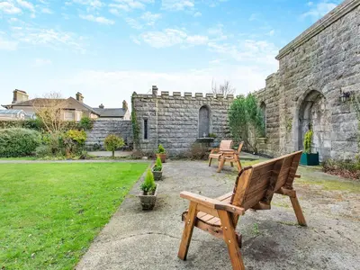 a garden with two benches and a stone building at Uk46865 - Helvellyn in Ulverston