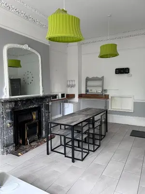 a dining room with a table and a fireplace at Triple room Private Bath Near LFC Free Street Parking No Breakfast in Liverpool