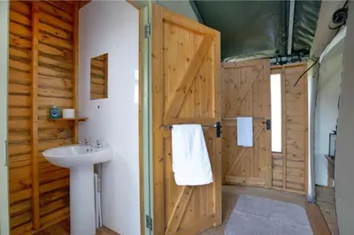 a bathroom with a wooden door and a sink at Redshank - Bleasdale in Chipping