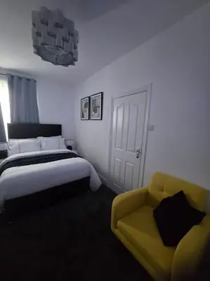 a bedroom with a bed and a yellow couch at Lily in Blackpool