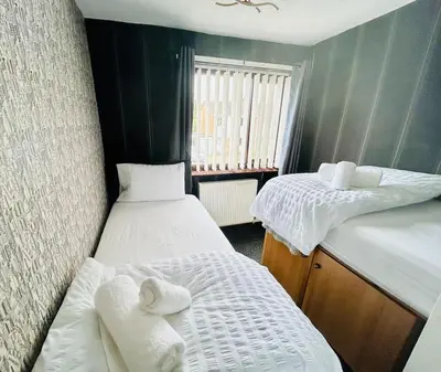a small room with two beds and a window at Fairholmes House in Thornton