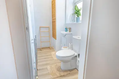 a bathroom with a white toilet in a room at Comfy 5 star Stays - 6 Bedrooms - Sleeps 8 - Free Parking & WiFi - Wirral in New Brighton