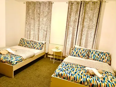 a bedroom with two beds and a window at Liverpool 4 Bed Home Sleeps 18 Free Parking in Liverpool