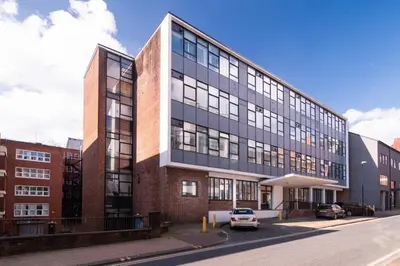 a large building with a car parked in front of it at Central Preston Modern 1 Bedroom Apartment in Preston