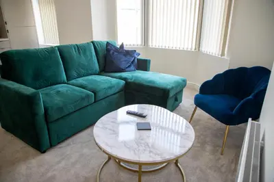 a living room with a green couch and a table at Balmoral Stays 3 - First Floor in Blackpool