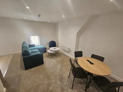 a living room with a blue couch and a table at Balmoral Stays 3 - First Floor in Blackpool