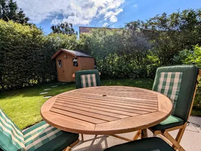 a wooden table and two chairs with a table and a yard at Bright Double Room l Smart TV l 5 Minute Walk from Train Station in Egerton