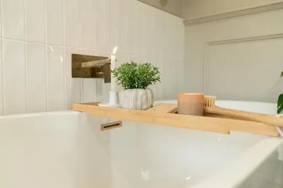 a bathroom with a wooden shelf with a candle and a plant at Heather room at field view cottage in Eccleston