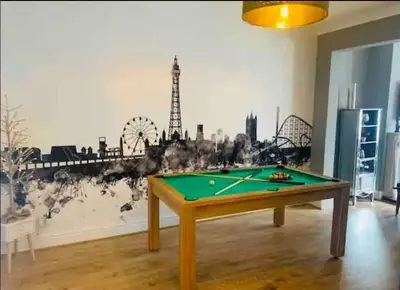 a room with a pool table in front of a wall at Seaside Suites in Blackpool