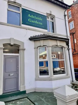 a white building with a sign for agraduate garden at Apartment 1 in Blackpool