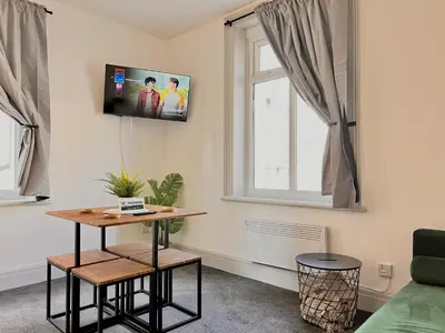 a living room with a table and a window at Apartment 6 in Blackpool