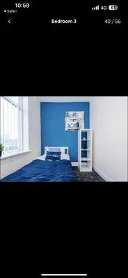 a bedroom with a blue wall and a bed at Walton Residence in Liverpool