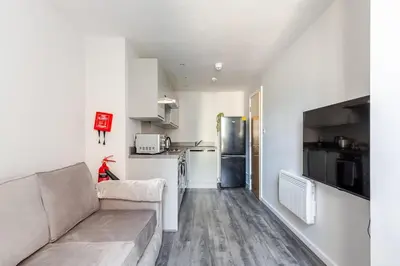 a living room with a couch and a kitchen at Liverpool Nightlife Spot City Centre 1BD apartment and Sofa bed in Liverpool