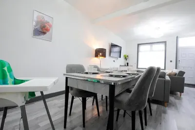 a living room with a dining room table and chairs at Dixon House, Sleeps 6, Free Parking, Long or Short Stays - by NMB Property in Horwich