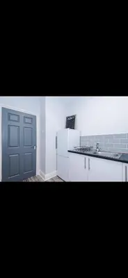 a kitchen with a white refrigerator and a door at Cherry Loft in Liverpool