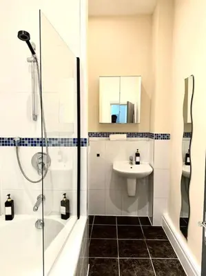 a white bathroom with a sink and a shower at City Centre 2 Bed 2 Bath Apartment in Preston