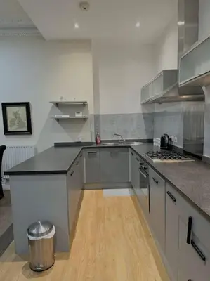 a kitchen with stainless steel appliances and a wooden floor at City Centre 2 Bed 2 Bath Apartment in Preston